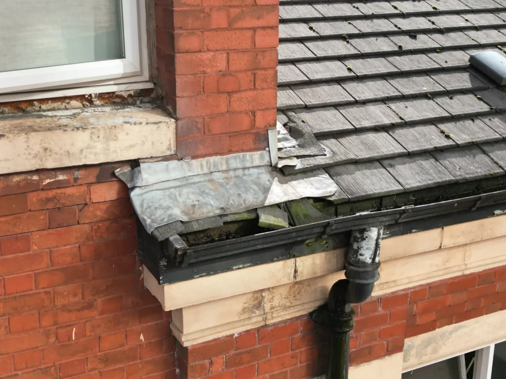 Drone close-up of a gutter with debris and a damaged joint